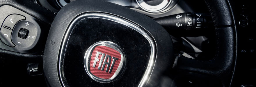 gros plan d'un volant d'un véhicule Fiat avec le logo apparent